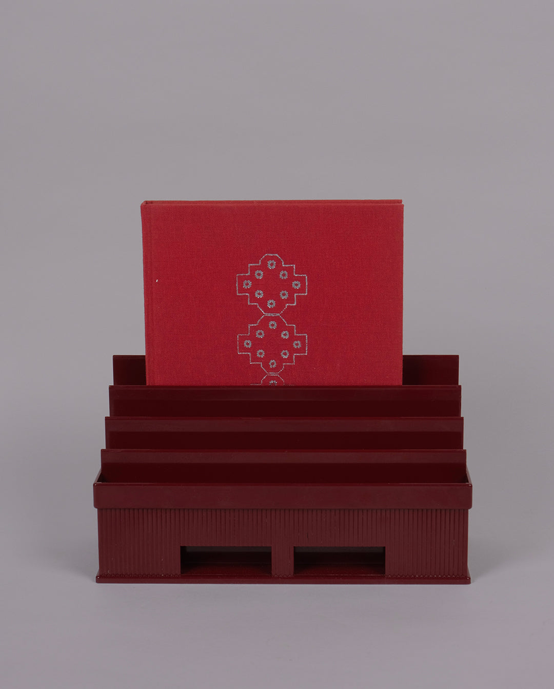 Porte-courrier en plastique de couleur bordeaux.