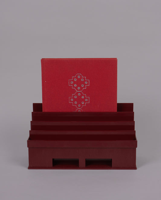 Porte-courrier en plastique de couleur bordeaux.
