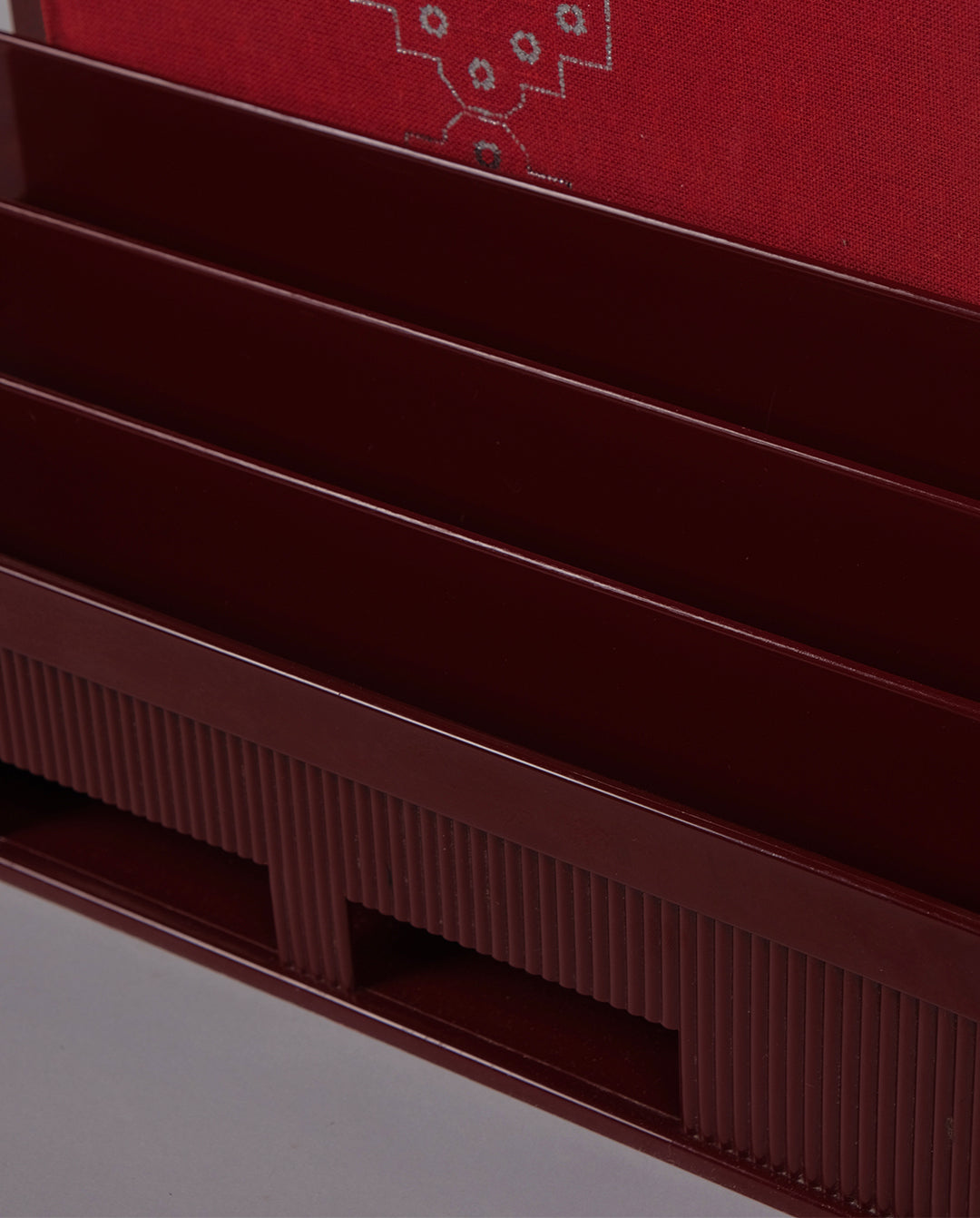 Porte-courrier en plastique moulé de couleur bordeaux.