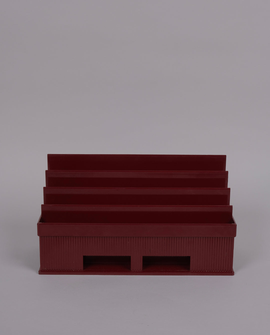 Porte-courrier en plastique de couleur bordeaux.