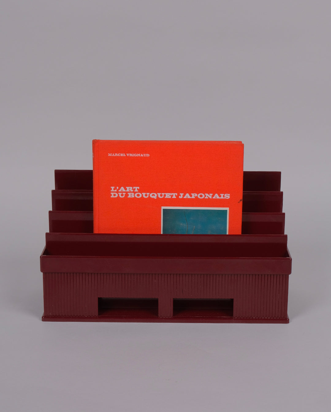 Porte-courrier en plastique de couleur bordeaux.