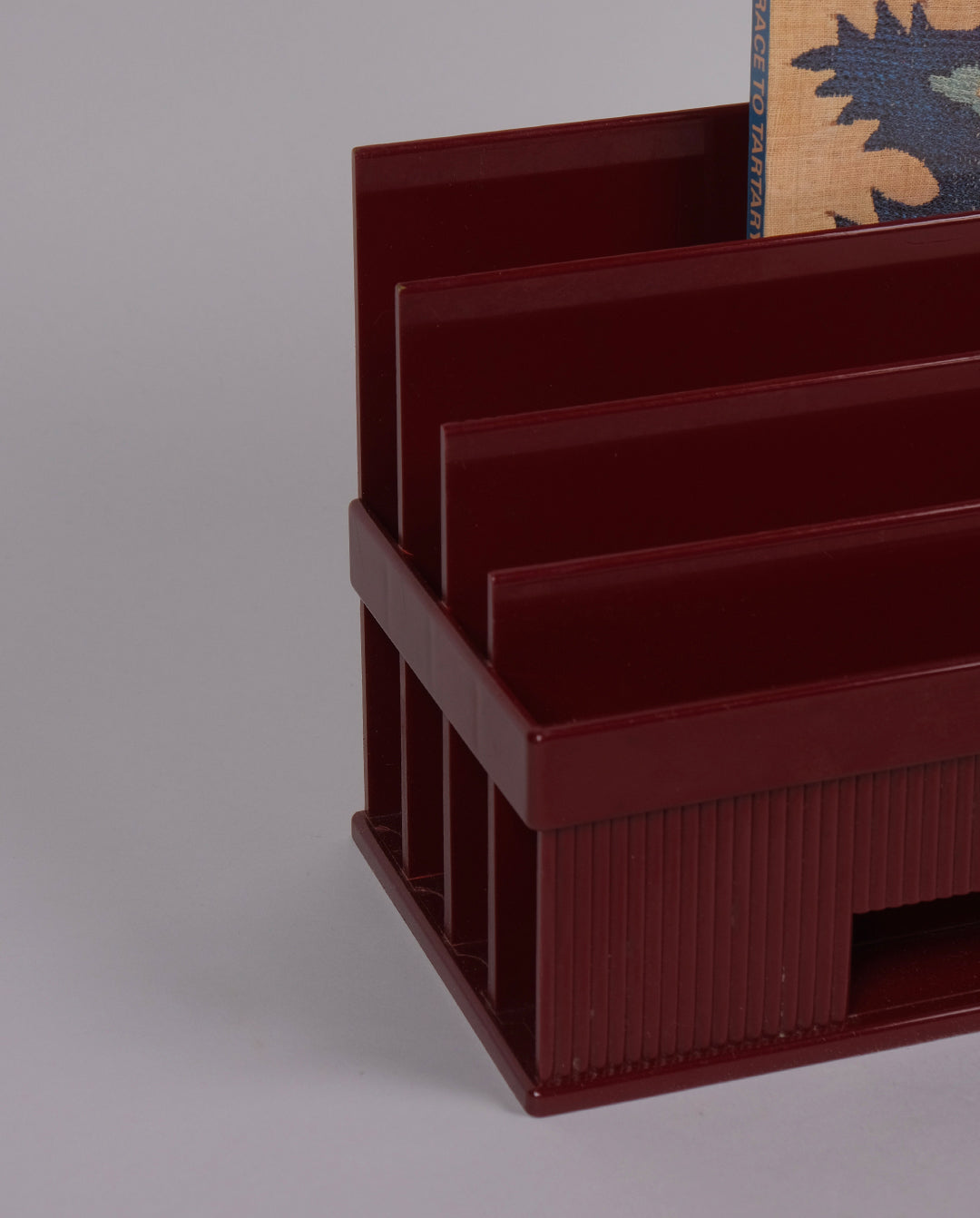 Porte-courrier en plastique de couleur bordeaux.