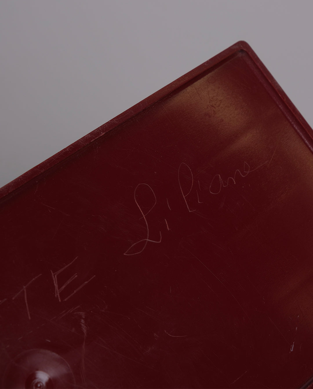 Porte-courrier en plastique de couleur bordeaux.