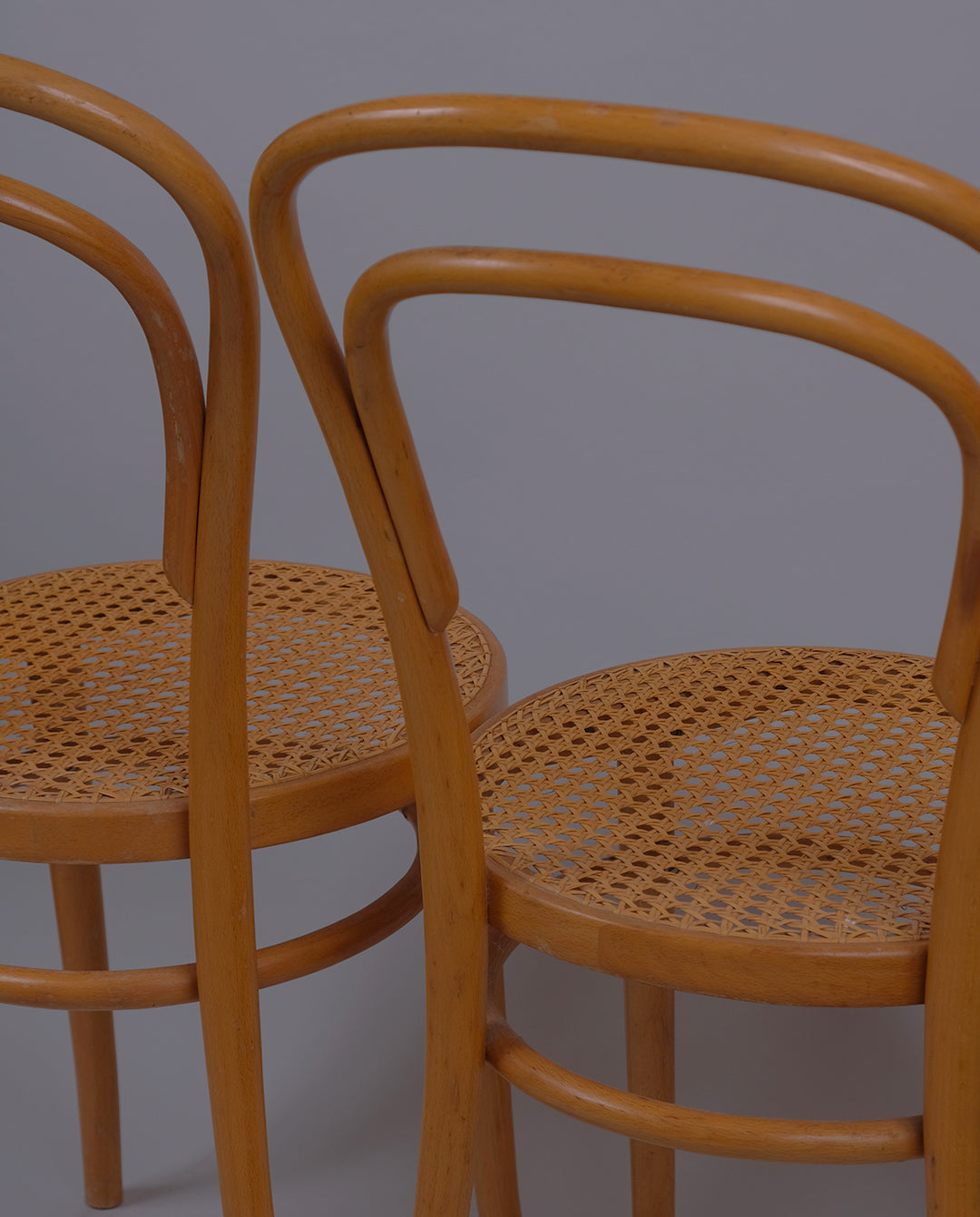 Deux chaises bistrot Thonet usine ZPM de Radomsko en Pologne avec dossier en bois courbé et assise en cannage de rotin