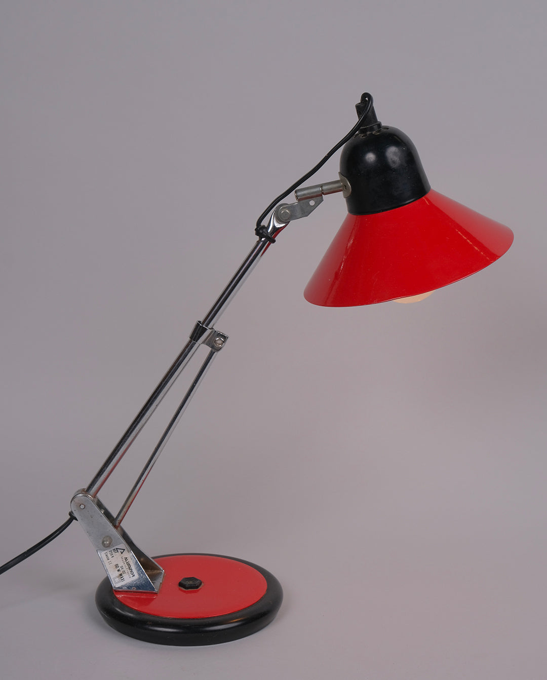 Lampe de bureau en métal laqué rouge et noirs et éléments en métal chromé.