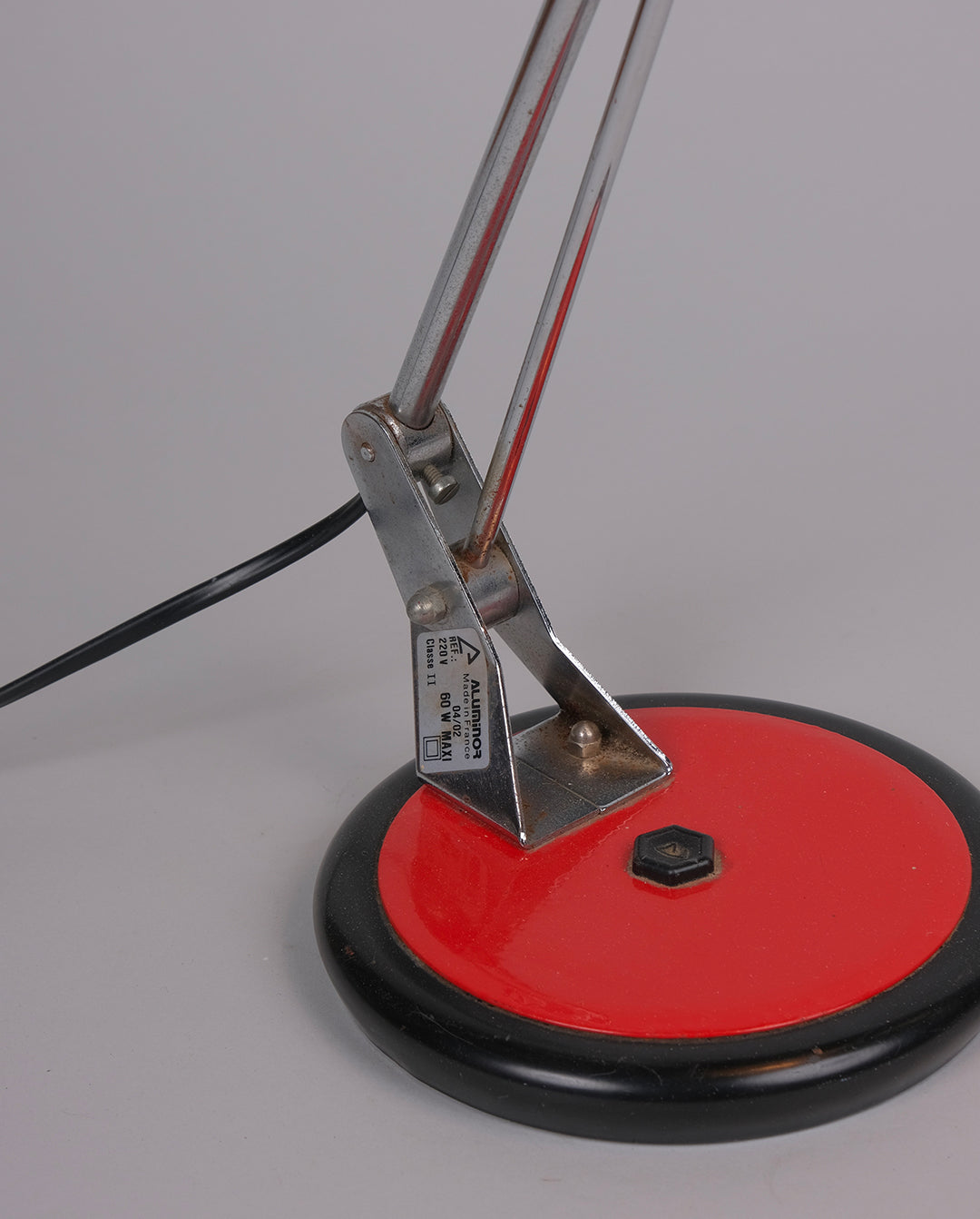 Lampe de bureau en métal laqué rouge et noirs et éléments en métal chromé.