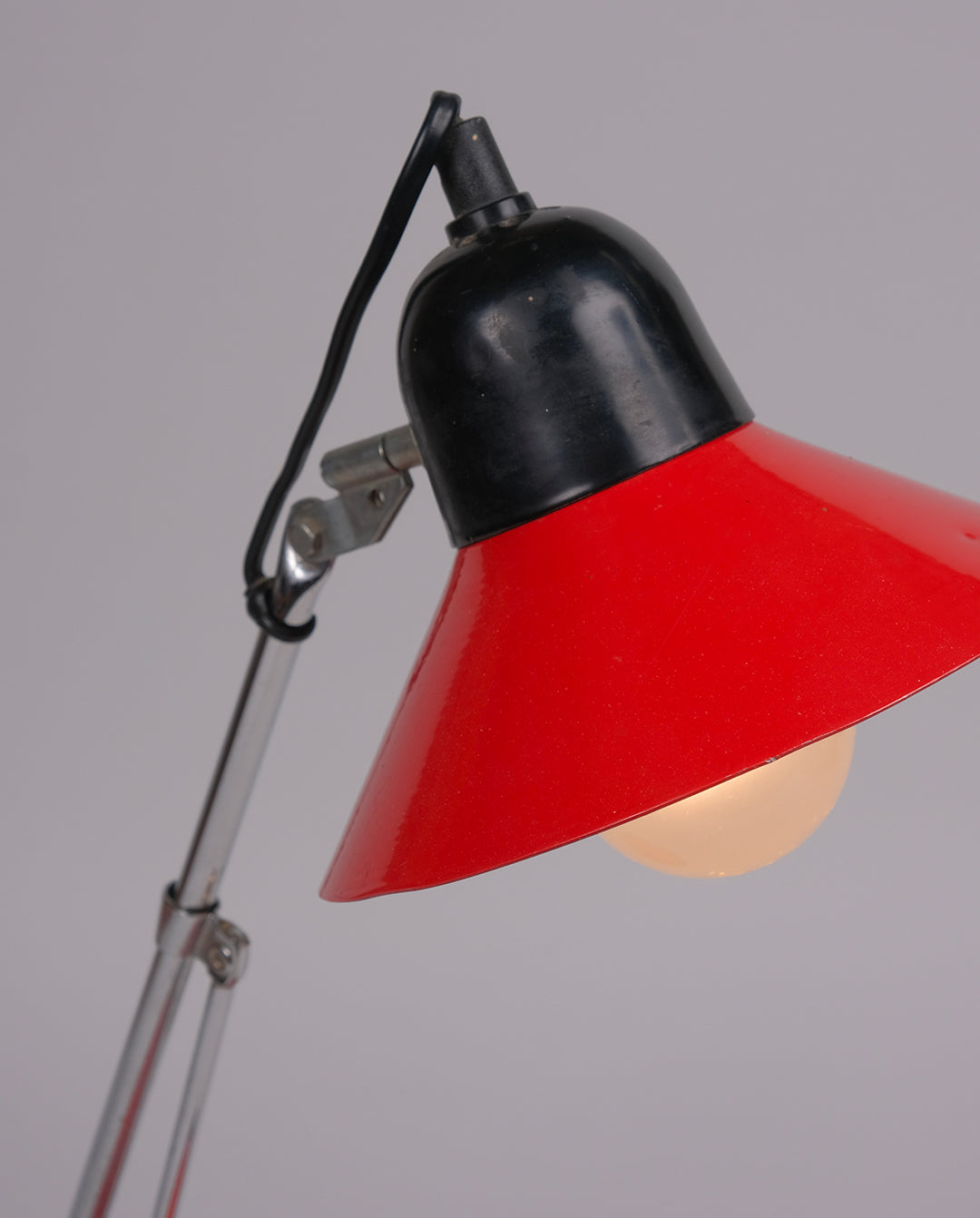 Lampe de bureau en métal laqué rouge et noirs et éléments en métal chromé.