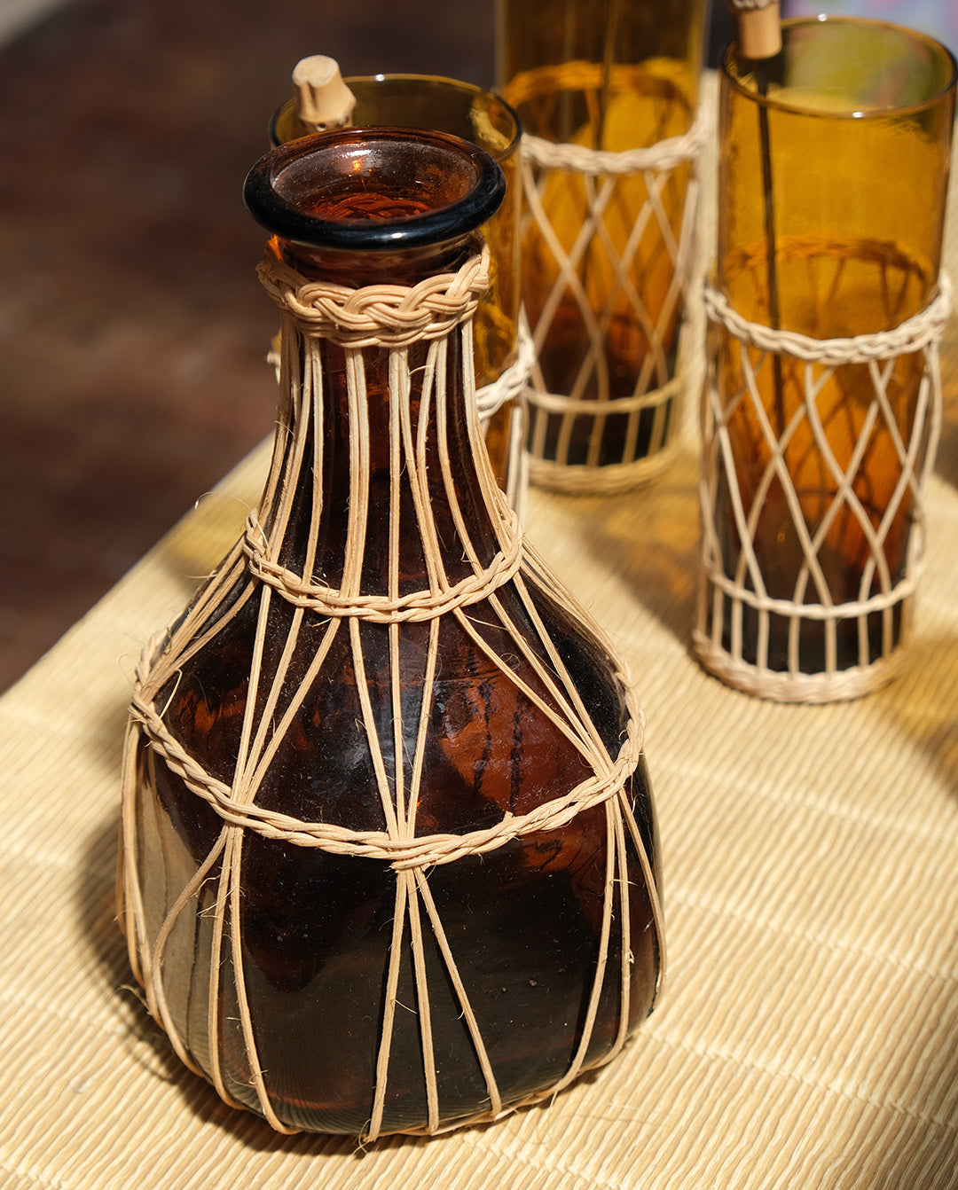 Carafe en verre ambré, habillage en osier, vintage