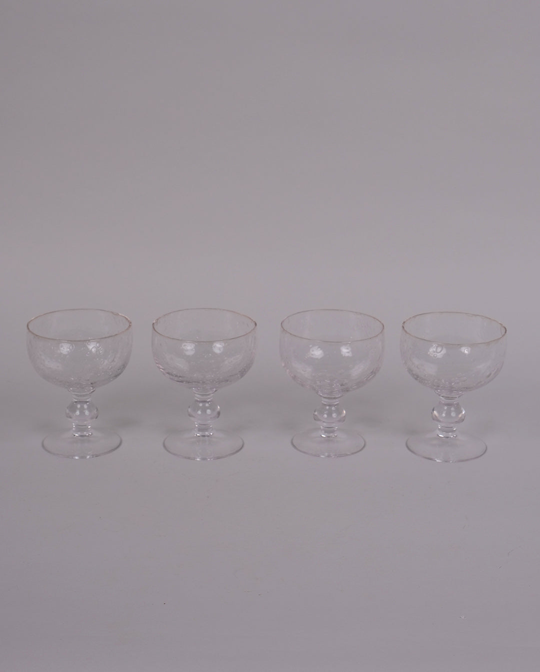 Ensemble de 4 verres à pied en verre bullé transparent.