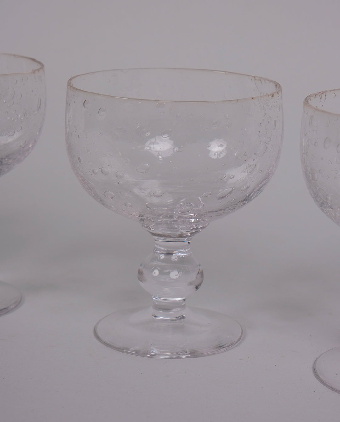 Ensemble de 4 verres à pied en verre bullé transparent.